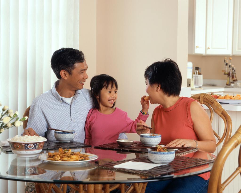 Famiglia asiatica che mangia a tavola